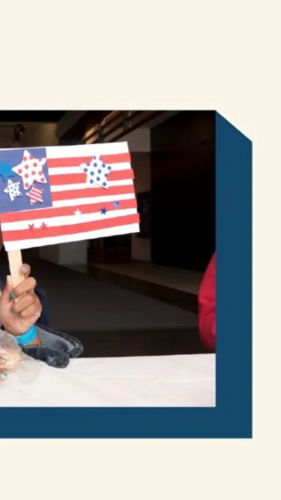 Little girl holding an American flag craft.