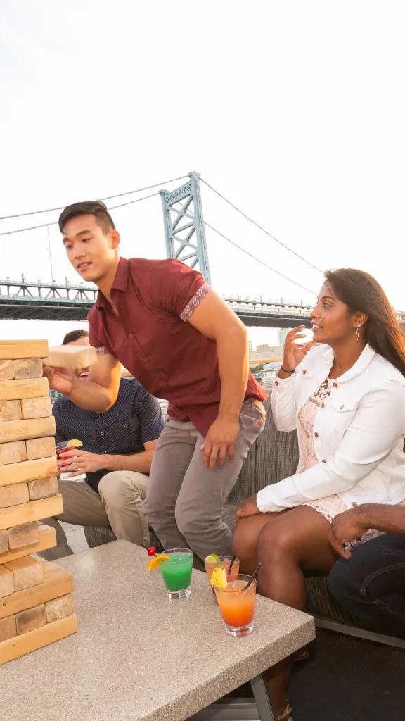 People playing the game jenga on the top deck. 