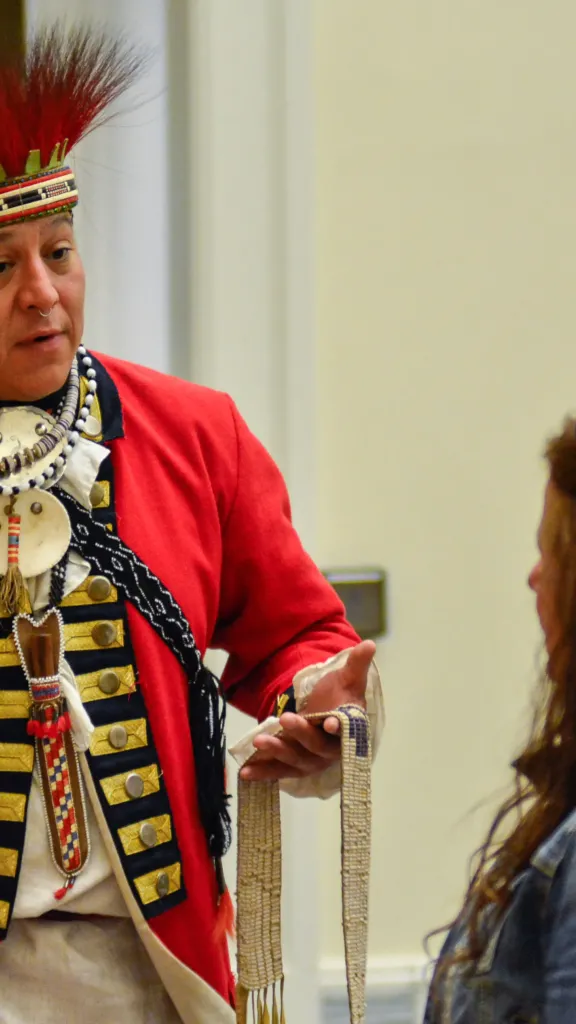 A Native American living history interpreter chats with guests at the Museum of the American Revolution