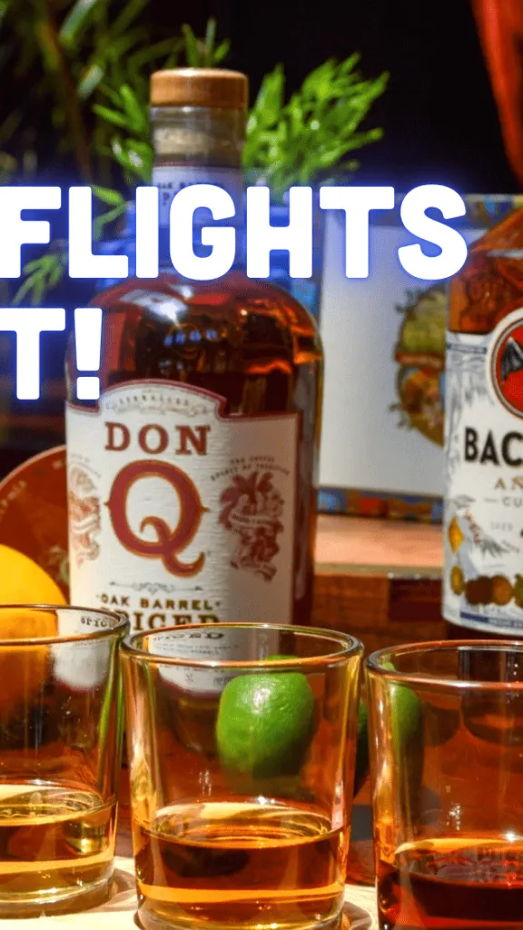 Rum Flight with three shot glasses, rum bottles in background