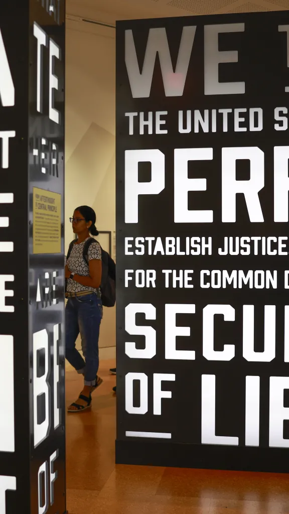 woman walking through signs with words of the Preamble of the Constitution