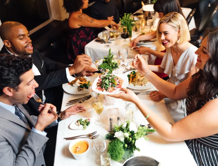 Group of people eating at table.